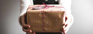 green gift guides for women image of lady holding package